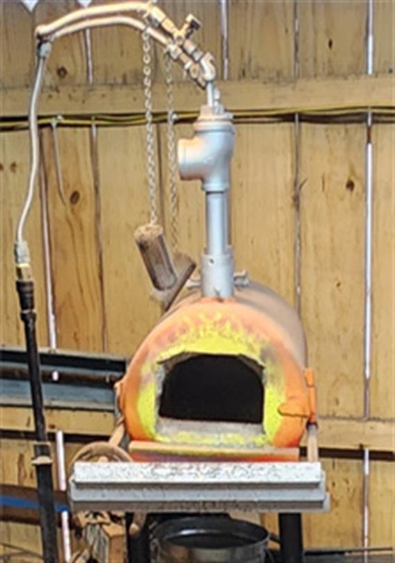 The gas forge is an insulated cylinder open on one end with gas pipes connected at the top.